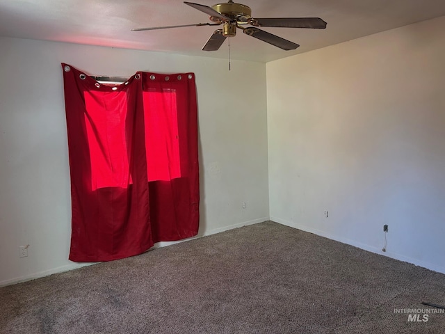 carpeted empty room featuring a ceiling fan and baseboards