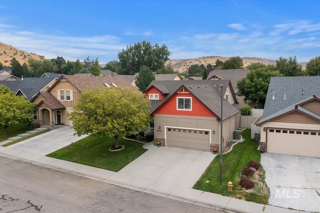 view of front facade featuring a mountain view, a garage, and a front lawn