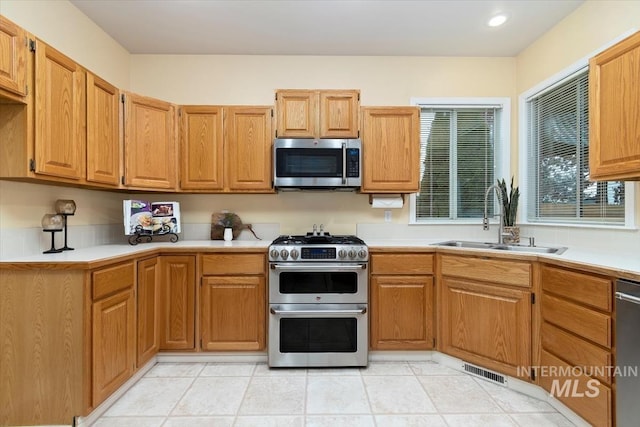 kitchen featuring a sink, visible vents, appliances with stainless steel finishes, and light countertops