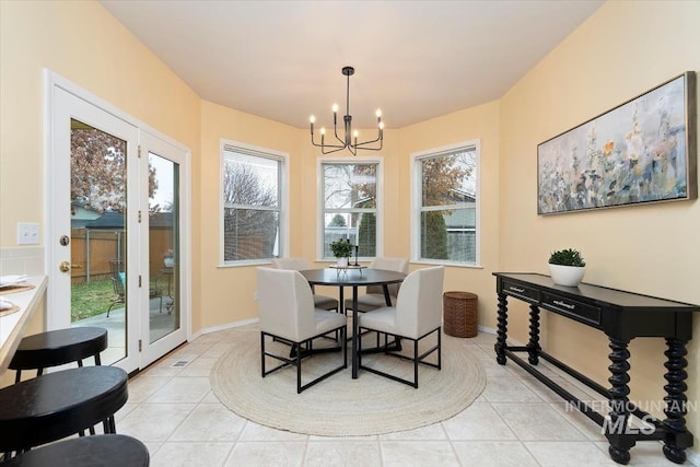 dining room featuring light tile patterned flooring, french doors, baseboards, and an inviting chandelier