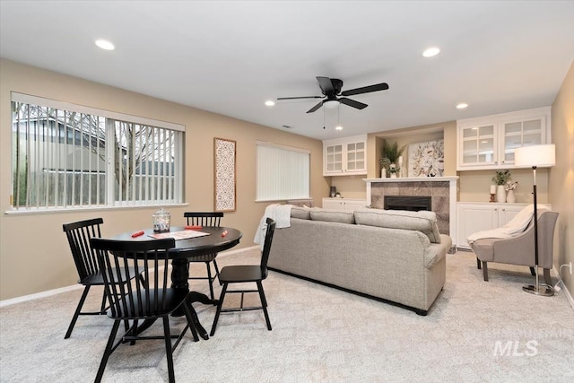 dining space featuring recessed lighting, light colored carpet, a tile fireplace, and baseboards