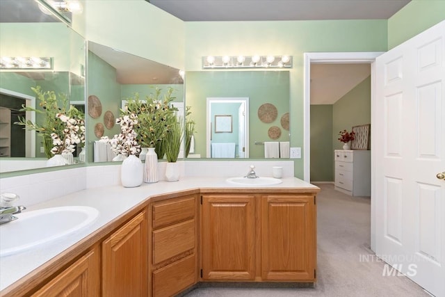 full bath featuring double vanity, lofted ceiling, and a sink