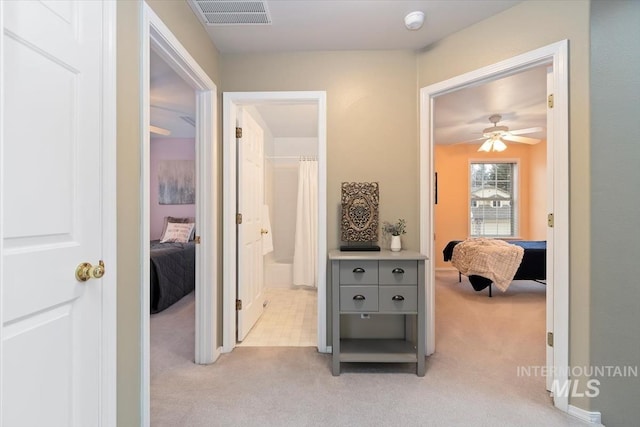 hallway with visible vents and light carpet