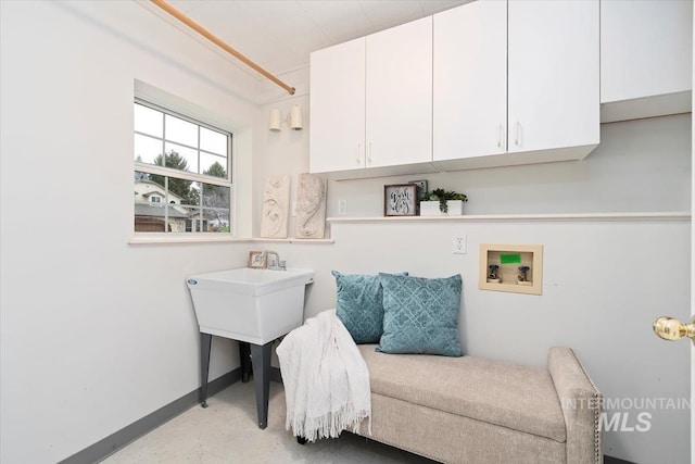 interior space featuring hookup for a washing machine, cabinet space, and baseboards