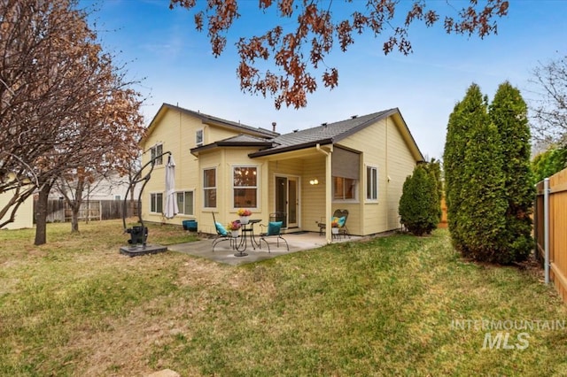 back of property with a yard, a patio area, and a fenced backyard