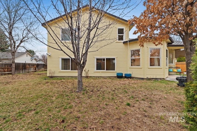 back of property with a patio area, a yard, and fence