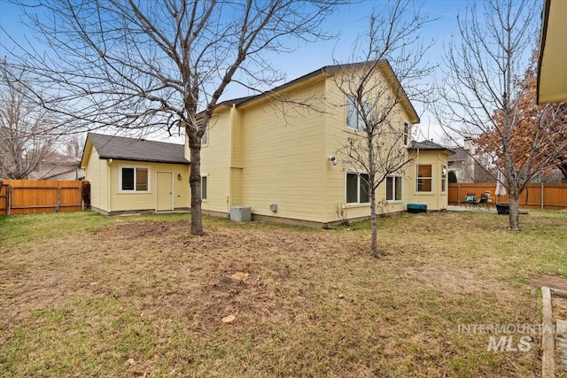 back of house with a lawn and a fenced backyard