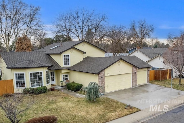 traditional home featuring a garage, a front yard, driveway, and fence