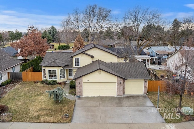 traditional home featuring an attached garage, driveway, and fence