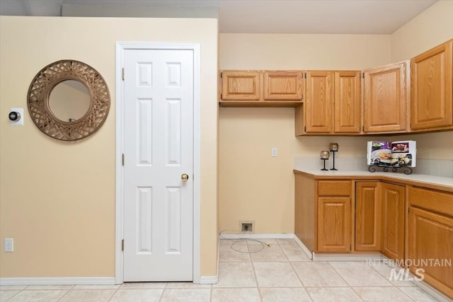 kitchen with light countertops, light tile patterned floors, and baseboards