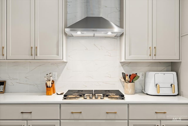4875 N Glenrock Ave, Meridian, ID 83646 - kitchen featuring stainless steel gas cooktop, decorative backsplash, wall chimney exhaust hood, light countertops, and white cabinets