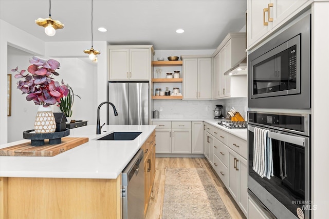 4875 N Glenrock Ave, Meridian, ID 83646 - kitchen featuring open shelves, appliances with stainless steel finishes, light countertops, light wood finished floors, and a sink