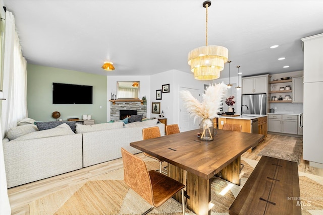 4875 N Glenrock Ave, Meridian, ID 83646 - dining area with wood finished floors, recessed lighting, a notable chandelier, and a stone fireplace