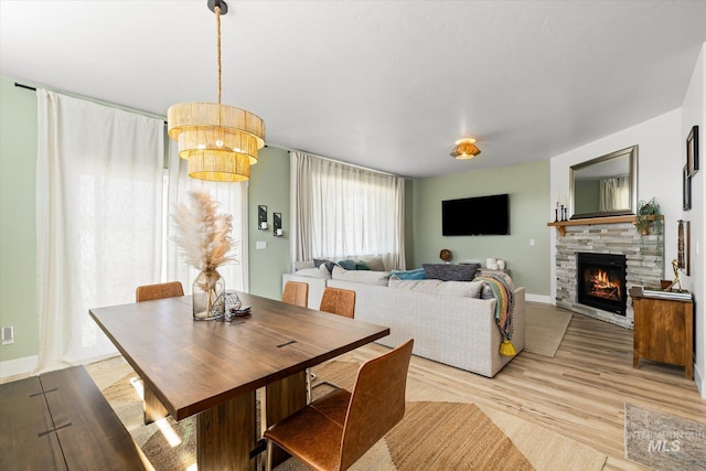 4875 N Glenrock Ave, Meridian, ID 83646 - dining area featuring a fireplace, light wood-type flooring, and baseboards