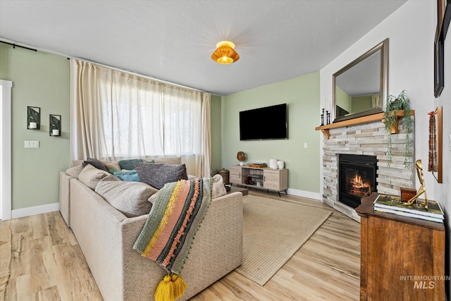 4875 N Glenrock Ave, Meridian, ID 83646 - living room featuring a fireplace, light wood-type flooring, and baseboards