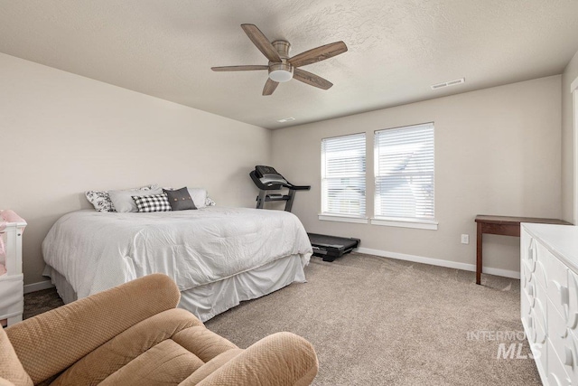 bedroom with light colored carpet, visible vents, a ceiling fan, a textured ceiling, and baseboards