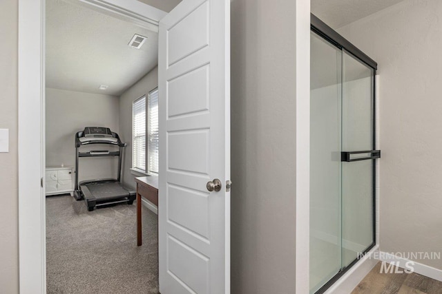 interior space with visible vents, a shower stall, and baseboards