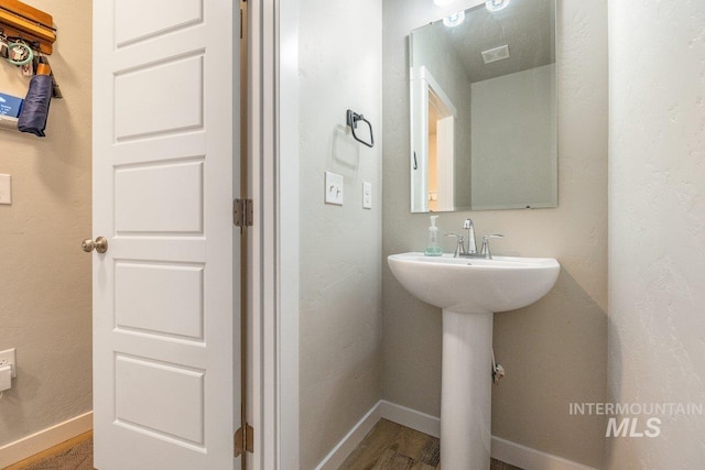 bathroom featuring baseboards, visible vents, and a sink