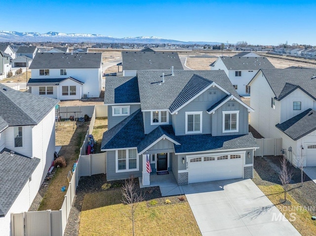 view of front of home with driveway, a fenced backyard, and a residential view