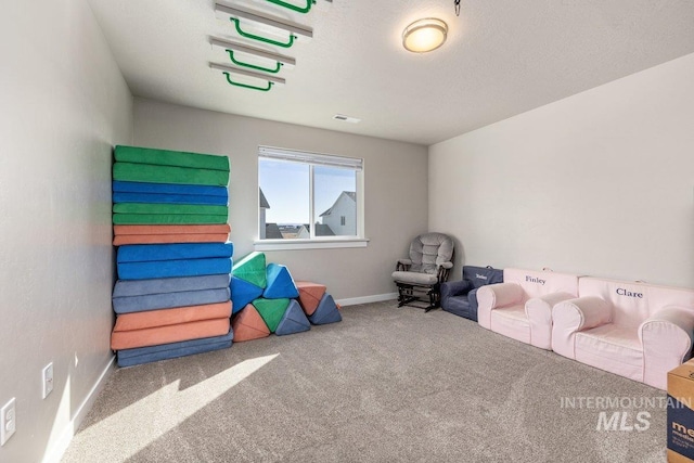 game room featuring carpet floors, a textured ceiling, and baseboards