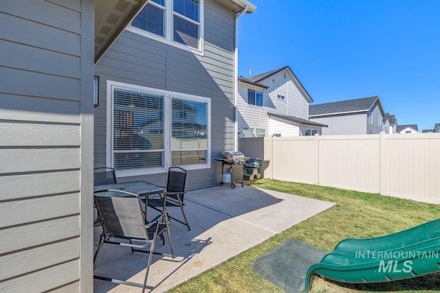 view of patio with fence and a grill