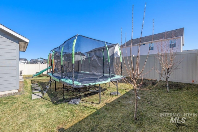 view of yard featuring a fenced backyard and a trampoline