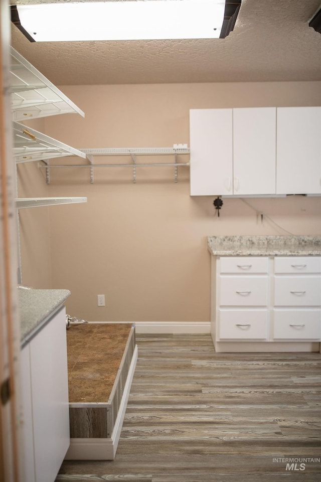 walk in closet with light hardwood / wood-style flooring