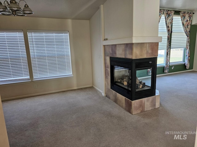 9788 Hwy 78, Hammett, ID 83627 - unfurnished living room featuring a tiled fireplace, carpet flooring, a notable chandelier, and baseboards