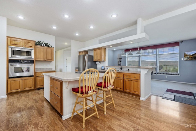 9788 Hwy 78, Hammett, ID 83627 - kitchen with light countertops, light wood-style floors, a peninsula, stainless steel appliances, and a breakfast bar area