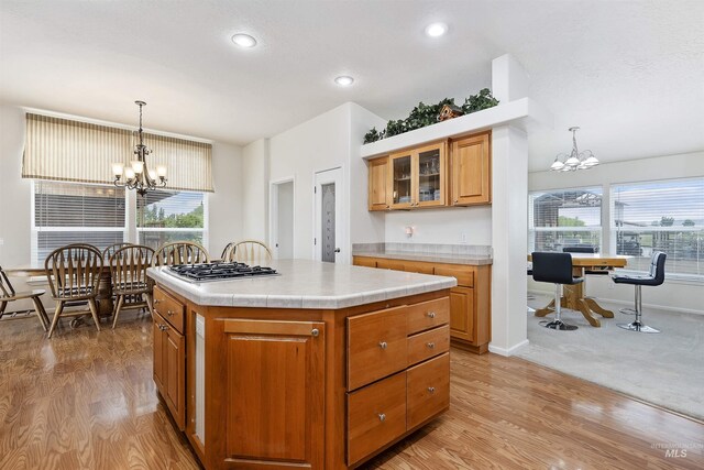 9788 Hwy 78, Hammett, ID 83627 - kitchen featuring a chandelier, light wood finished floors, brown cabinets, and a healthy amount of sunlight