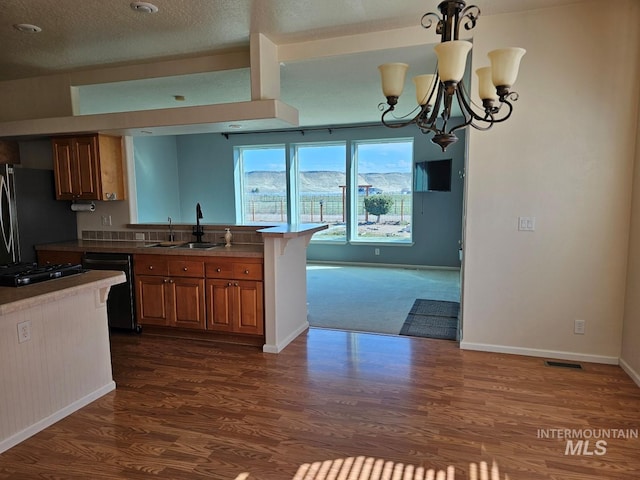9788 Hwy 78, Hammett, ID 83627 - kitchen with freestanding refrigerator, brown cabinetry, a peninsula, dishwasher, and a sink