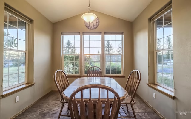 dining area featuring baseboards, plenty of natural light, and vaulted ceiling