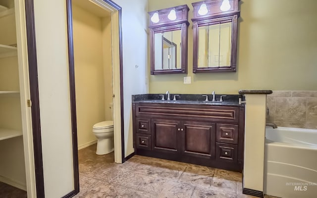 bathroom with toilet, a garden tub, double vanity, and a sink