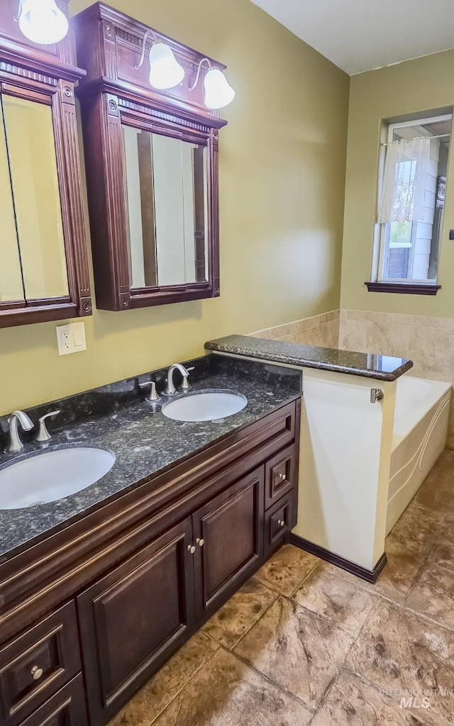 full bath with a sink, double vanity, tile patterned flooring, and a garden tub