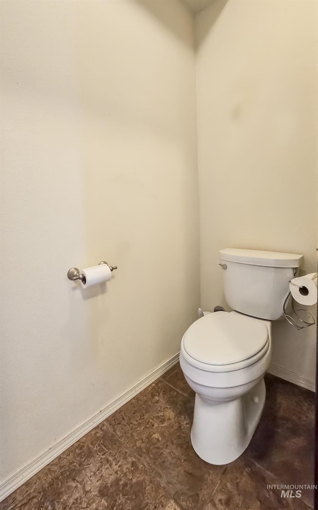 bathroom featuring baseboards and toilet