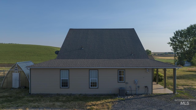 view of side of property with central AC and a yard