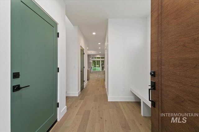 corridor featuring baseboards, recessed lighting, and light wood-style floors