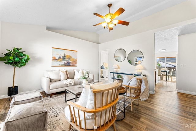 living room with hardwood / wood-style flooring, ceiling fan, and lofted ceiling