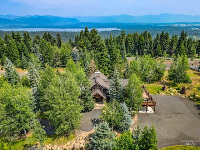 view from above of property featuring a heavily wooded area and a mountainous background