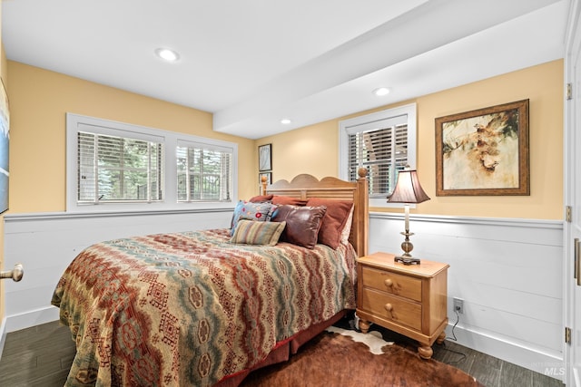 bedroom with dark wood-style flooring, a wainscoted wall, and recessed lighting