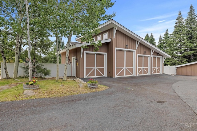 view of outbuilding featuring fence and an outbuilding