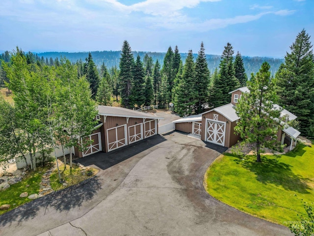 aerial view of property and surrounding area featuring a forest