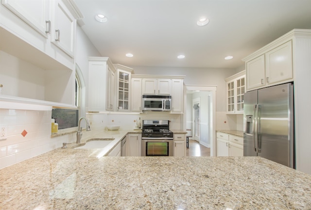 6174 N Queensbury Pl, Boise, ID 83713 - kitchen with appliances with stainless steel finishes, a sink, light stone counters, recessed lighting, and decorative backsplash