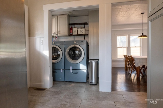 707 9th Ave S, Nampa, ID 83651 - clothes washing area featuring washing machine and dryer, cabinet space, and a wainscoted wall