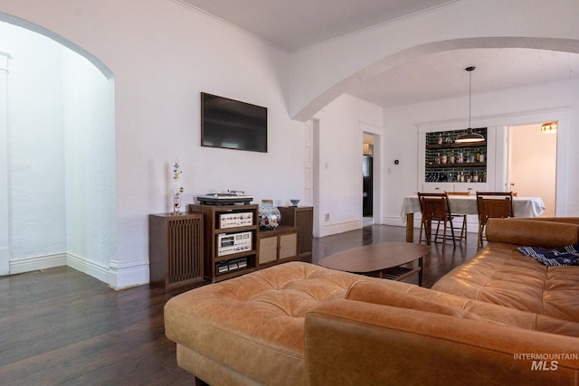 707 9th Ave S, Nampa, ID 83651 - living area with arched walkways, dark wood-style floors, baseboards, bar, and ornamental molding