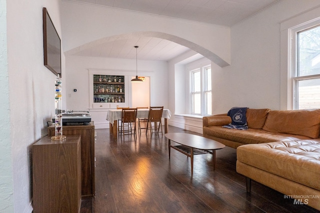 707 9th Ave S, Nampa, ID 83651 - living area with arched walkways, dark wood-type flooring, ornamental molding, and plenty of natural light