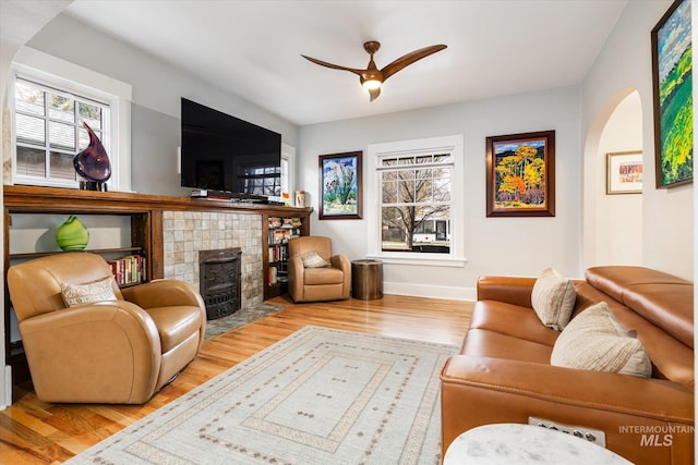 living room with a wealth of natural light, a ceiling fan, and wood finished floors