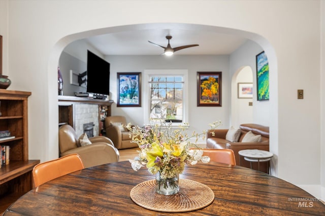 dining area featuring a ceiling fan and arched walkways