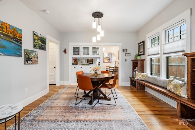 dining space featuring light wood-style flooring and baseboards