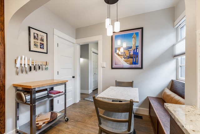 dining space with baseboards and hardwood / wood-style floors